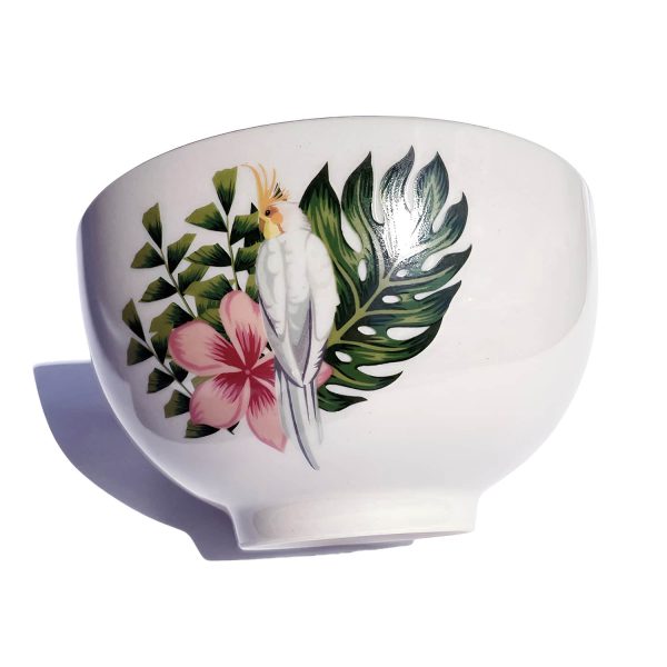 Bloomingville Moana Müslischale Blumen: nach links geneigte beige Schale mit oberen Gold-Rand mit Abbildung von Papagei mit Palmenblatt und Blüte auf weißem Hintergrund