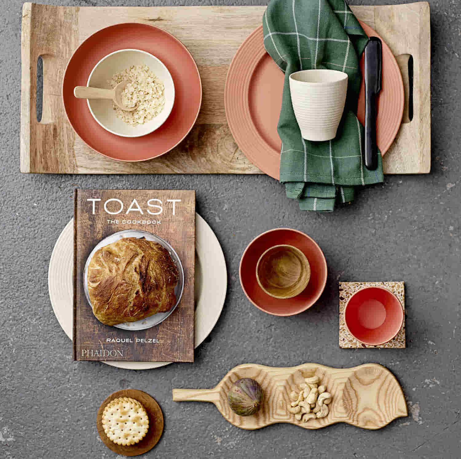 Motivbild Bloomingville Sooji Müslischalen bunt: Schalen, Toast Kochbuch, Becher, Teller optisch ansprechend angeordnet auf grauem Tisch